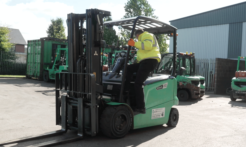 Green Mitsubishi electric forklift in an industrial yard